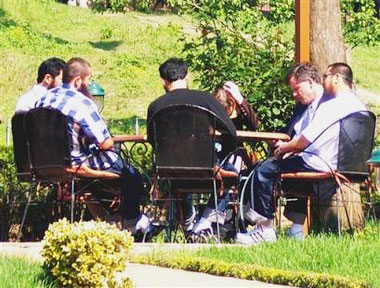 U.S. attorney Sabin Willett, second right, and five Uighurs, Chinese Muslims, released from the Guantanamo Bay detention center have lunch at a restaurant in Tirana Monday May 8, 2006. China on Tuesday May 9, 2006, demanded the return of five Chinese Muslims released from the Guantanamo Bay detention center, blasting a U.S. decision to allow them to seek asylum in Albania. The United States allowed the five Chinese to go to Albania after concluding they posed no terrorist threat to the United States but might face persecution if they returned to China. (AP