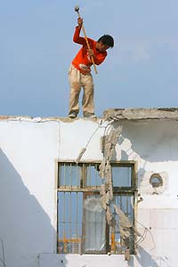 A labourer works at a construction site in Nanjing, the capital of east China's Jiangsu province, July 18, 2006. [Reuters]