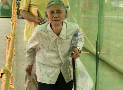 An aged woman waits to cast a vote on the demolishment and reconstruction of old buildings in Juixiaqiao Sub-district in Beijing, June 9, 2007. Local government and the real estate developer jointly organize the vote on Saturday to see if majority residents of over 5000 families accept the new compensation policy after failed attempts to reach an agreement through other ways. Both notary officials and supervisors are invited to monitor the vote that runs from 9 a.m. to 9 p.m. at six ballot booths. [Sun Yuqing/www.tsdianying02.cn]