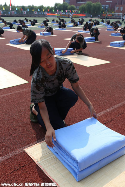 Freshmen fold quilts in 80 sec during military training