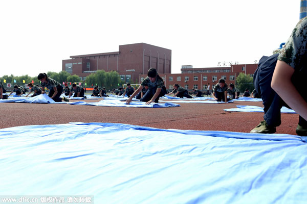 Freshmen fold quilts in 80 sec during military training