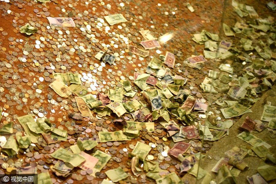 Tourists toss coins at ruins of Leifeng Pagoda