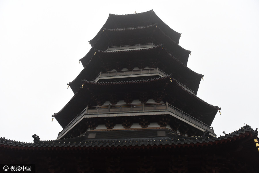 Tourists toss coins at ruins of Leifeng Pagoda