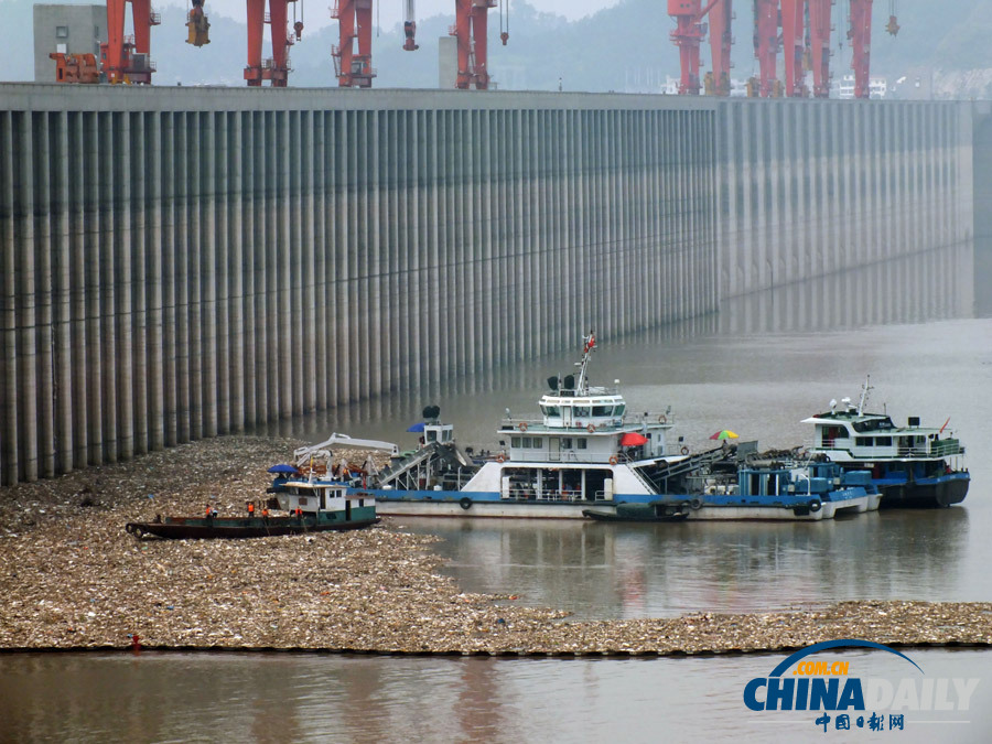 三峽大壩前聚集大量漂浮垃圾 工人忙打撈