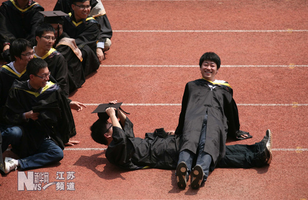 南京工業大學幾名畢業生在校園里拍攝趣味畢業照留念