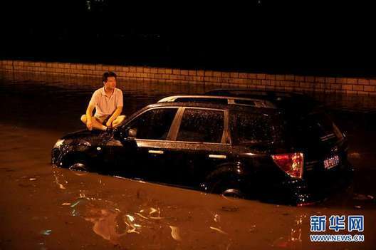 北京夜降暴雨 積水中勇現“淡定哥”(組圖)