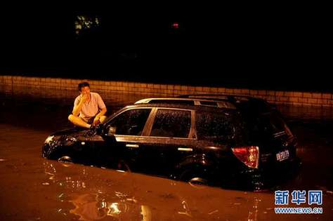 北京夜降暴雨 積水中勇現“淡定哥”(組圖)