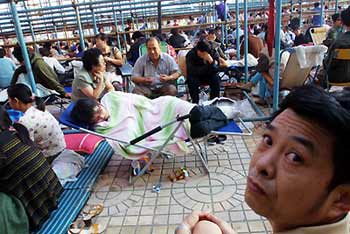 People queue to buy economically affordable apartment, which are meant to provide housing for middle-and-low-income families, in Beijing. [newsphoto/file]