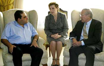 El Salvador President Elias Antonio Gonzalez (L) and US Secretary of Defense Donald Rumsfeld (R) conduct an early morning meeting at the presidential palace in San Salvador November 12, 2004. At center is a translator. [Reuters]