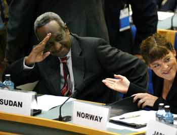 Sudan First Vice President Ali Osman Mohamed Taha (L) salutes Sudan People's Liberation Movement leader John Garang (unseen) as he sits next to Norwegian Minister of International development Hilde Johnson (R) during the U.N. Security Council meeting in Nairobi November 19, 2004. [Reuters]