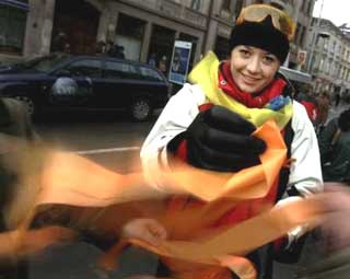 A young woman distributes orange ribbons to people during pro opposition demonstration in the center of Lviv, November 27, 2004. The speaker of Ukraine's parliament, pressed by the West to stage a new presidential election, said on Saturday the best option to end turmoil in the streets was to declare this week's disputed poll invalid. 