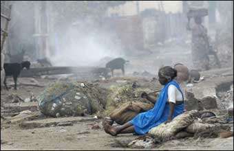 An elderly Indian woman sits in the rubble of the fishing colony of Akkrapattai in Nagapattinam some 350 kms south of Madras. The first outbreaks of communicable diseases are now being seen in areas hit by the killer tidal waves in Asia, a senior World Health Organisation (WHO) official said.(AFP