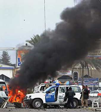 An Iraq fireman sprays water on destroyed vehicles after a car bomb exploded near the party headquarters of Iraqi Prime Minister Iyad Allawi in western Baghdad January 3, 2005. [Reuters]