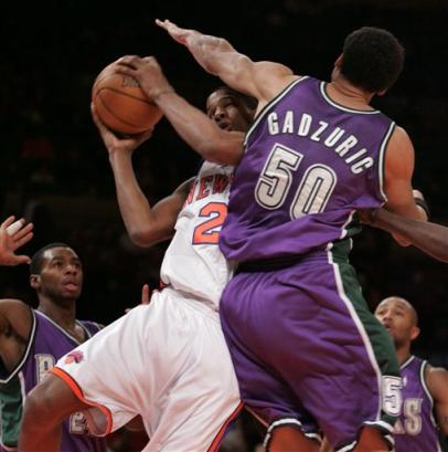 Milwaukee Bucks ' Desmond Mason goes up for a shot against New York Knicks ' Nazr Mohammed , right and Michael Sweetney Sunday, Jan. 23, 2005 at Madison Square Garden in New York. [AP]