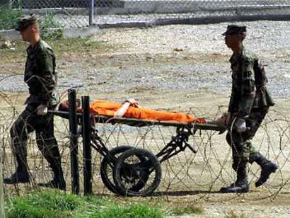 The U.S. military extended by four weeks its investigation into FBI (news - web sites) allegations that prisoners were tortured at the Guantanamo detention camp and said on February 1, 2005 it needed more time to question witnesses in several countries. The military's Southern Command, which oversees the controversial camp for foreign terrorism suspects, had asked two officers to investigate and report back by Feb. 1. Military Police at Guantanamo bring a detainee from an interrogation room in this February 6, 2002 file photo. Photo by Marc Serota/Reuters 