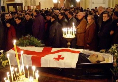 Georgians pay tribute to late Prime Minister Zurab Zhvania as they pass his coffin with his body covered by a Georgian flag in the Holy Trinity cathedral in Tbilisi, Georgia, late Saturday, Feb. 5, 2005. The stunned ex-Soviet republic struggles to come to grips with the unexpected death of the man who had been expected to champion the government's ambitious anti-corruption program and efforts to peacefully rein in separatist regions. (AP Photo/George Abdaladze) 