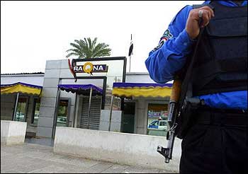 An Iraqi policeman stand guard in front of one of the main offices of Iraqna, a subsidiary of the Egyptian telecom firm Orascom, after Gunmen abducted four Egyptian telecoms engineers in front of their Baghdad house. [AFP]