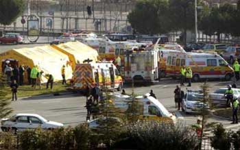 Ambulances stand near the scene where a powerful car bomb exploded in Madrid, Wednesday, Feb. 9, 2005. The car bomb exploded following a telephone warning from a caller claiming to represent the armed Basque separatist group ETA, injuring at least 39 people, officials said. (AP 