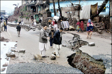 Kashmiris survey a devastated street following an avalanche in Muzaffarabad. Forty-six people were killed in a series of avalanches in Pakistan-controlled Kashmir (news - web sites), police said.(AFP/Zeeshan Naqash) 