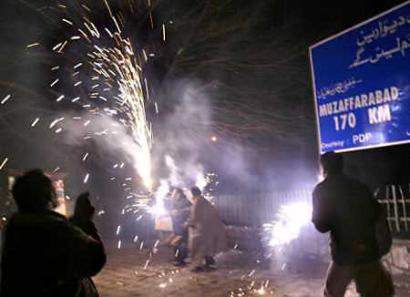 Kashmiris light firecrackers to celebrate the start of a bus service across a ceasefire line, in Srinagar, the summer capital of Indian administered Kashmir, February 16, 2005. Kashmiris on both sides of a ceasefire line were ecstatic after arch-rivals Pakistan and India finally agreed to start a bus service between the divided Himalayan territory. [Reuters]