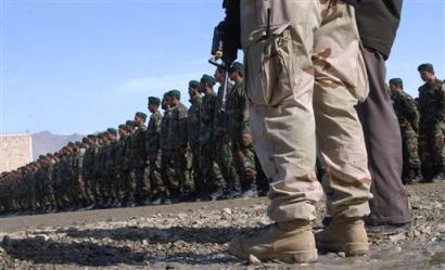 A U.S. soldier, front, attends the graduation ceremony of new Afghan National Army soldiers at the Military Training Center in Kabul, Afghanistan, on Sunday, Feb. 13, 2005. The U.S. military has doubled the number of its soldiers embedded inside the Afghan army, a spokesman said Sunday, Feb. 20, 2005, bolstering a force supposed to relieve American and NATO troops in warlord-plagued provinces and along the Pakistani border. [AP/file]