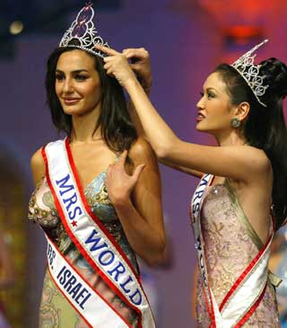 New Mrs.World 2005 Sima Bakahr (L) of Israel is crowned by last year's Mrs.World Suzanna Vicheinrut of Thailand during a function in Lonavala, 140 km (88 miles) from Bombay February 25, 2005. Bakahr was crowned Mrs.World from 41 contestants around the world.