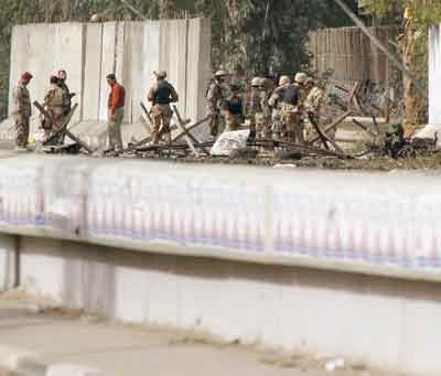 Iraqi soldiers work at the scene of a car bomb explosion outside an Iraqi Army recruiting centre in southern Baghdad March 2, 2005. At least six men lining up to join the Iraqi Army and over 20 were injured by the blast. [Reuters]