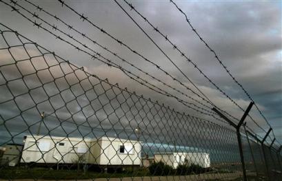 The caravans of the unauthorized Jewish settlement outpost of Migron are seen behind the fence near the West Bank city of Ramallah on Wednesday March 9, 2005. An inquiry into the establishment of about 105 unauthorized West Bank settlement outposts found widespread complicity of successive Israeli governments, and recommended Wednesday that prosecutors consider investigating some of those involved. [AP]