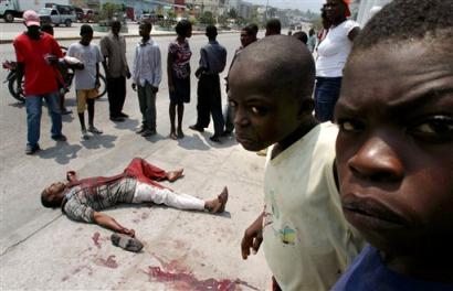 A man lies dead on a road in Port-au-Prince, Haiti, Thursday, March 24, 2005. Gunfire erupted at a protest where several thousand people attended calling for the return of ousted President Jean-Bertrand Aristide. [AP]