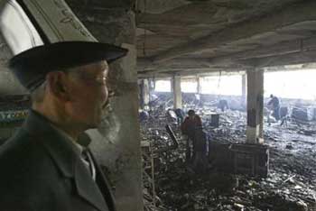 An elderly Kyrgyzs man looks on as people search through the rubble left by looters in a shopping mall in Bishkek, Kyrgystan, Saturday, March 26, 2005. Serious looting broke out in Kyrgyzstan's capital Thursday after opposition supporters seized the presidential headquarters and ousted the government from power. Kyrgyzstan's parliament on Saturday set June 26 as the date for elections to replace ousted President Askar Akayev, and the opposition leader who took the nation's helm after protesters seized the government headquarters said he plans to run. (AP 