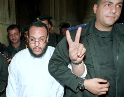 Egyptian national Mahmoud Mohammed Eid Dabous, left, flashes a V sign as he is accompanied by an Egyptian policeman before his verdict at a Cairo court, Sunday, March 27, 2005. Dabous was sentenced to life imprisonment for conspiring to assassinate President Hosni Mubarak (news - web sites), and an additional 10 years for passing information to Iran (news - web sites) to plan attacks on Egypt and Saudi Arabia. (AP Photo/Nasser Nouri) 