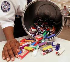 A Transportation Security Administration officer shows off some of the 160 some lighters taken from passengers going through security at Hartsfield Jackson Atlanta International Airport in Atlanta early Thursday, April 14, 2005. Starting Thursday, air travelers have to leave their lighters at home. Unlike guns, knives and other dangerous items that a passenger cannot carry aboard but may stow in checked bags, lighters are banned everywhere on a plane. (AP