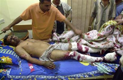 A relative attends to a man, injured in a car bomb explosion, at the al-Hakim Local Hospital in Baghdad, Iraq, Sunday, April 24, 2005. Two suicide car bombs exploded nearby in quick succession killing 15 people and injuring 40, Iraqi police said. (AP