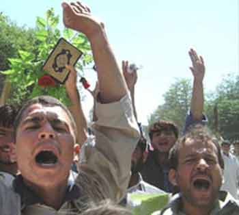 Afghan university students march in the streets in Jalalabad, Afghanistan, carrying copies of the Qur'an and sticks and tree branches Wednesday. (AP