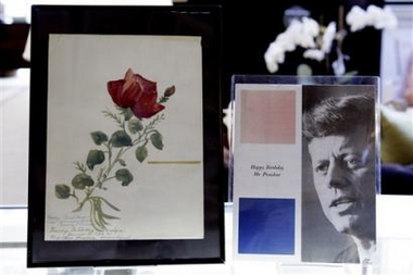 A painting of a red rose by actress Marilyn Monroe, left, meant to be a birthday gift for President John F. Kennedy and dated June 1, 1962, and a program from Kennedy's birthday celebration that took place on May 19, 1962, where Monroe sang her famous rendition of 'Happy Birthday,' are displayed at Barclay Butera Tuesday, May 31, 2005, in Los Angeles, in preparation for the Marilyn Monroe Estate Auction to be held live and online on June 4th. Monroe died before she was able to give the painting to Kennedy. (AP