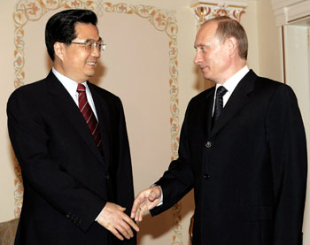 Russian President Vladimir Putin (R) and Chinese President Hu Jintao greet each other as they meet at a presidential residence Novo-Ogaryovo outside Moscow, June 30, 2005. Chinese President Hu Jintao began a four-day visit to Russia hoping to secure access to more crude oil and gas to fuel his country's booming economy. [Reuters]