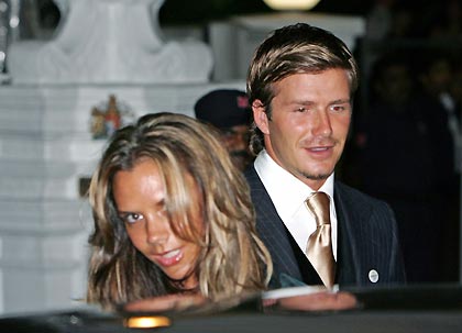 England's soccer captain David Beckham (R) and his wife Victoria leave a dinner reception at the British High Commissioner's residence in Singapore July 4, 2005. [Reuters]