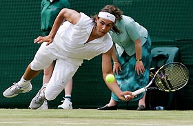 Spain's Rafael Nadal dives to return the ball to Luxembourg's Gilles Muller in their men's singles second round match at the Wimbledon tennis championships in London, June 23, 2005. 