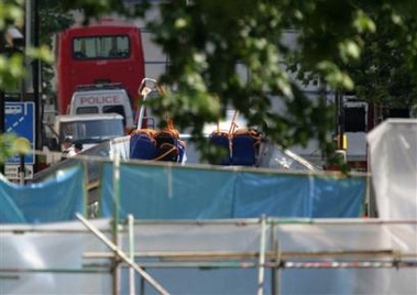 The wreckage of bus No.30 sits behind a police barrier with its second level open to the elements after Thursday's bomb attack in Travistock Square, London, Sunday, July 10, 2005.