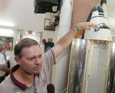 NASA Public Affairs Officer Kyle Herring points to the windows on a static display of the Space Shuttle Discovery at the Kennedy Space Center at Cape Canaveral, Fla., on Tuesday, July 12, 2005.