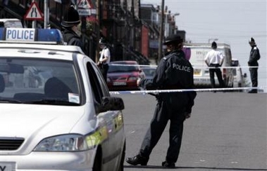 Police stand guard near a house on Tempest road in the Beeston district of Leeds, England, Tuesday July 12, 2005 after raids throughout the area in connection with the recent terrorist bombings in London. (AP 