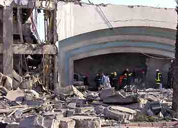 Rescue workers look for injured people under the rubble of a hotel after it was destroyed by a bomb late last night in the red sea resort of Sharm el-Sheikh July 23, 2005. [Reuters]