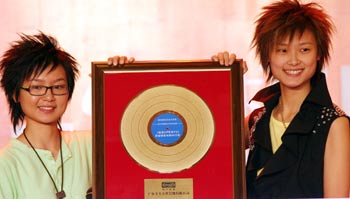 hou Bichang (L) and Li Yuchuan display the super girls' first album "terminal PK" in the opening ceremony held in Beijing, capital of China on August 29, 2005. [newsphoto]