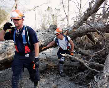 Georgia Search and Rescue Central members search a neighborhood in Violet, in the suburbs of New Orleans, September 10, 2005. It is believed the death toll in Louisiana will be lower than first reported but searchers continue looking for survivors and bodies. [Reuters]