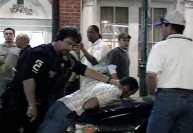 In this image taken from video, a man resembling University of South Florida student Calvin Briles, 21, is seen being held down on a car by unidentified law enforcement personnel in the French Quarter section of New Orleans, Saturday Oct. 8, 2005. Briles told the Bradenton Herald newspaper that he and another USF student Mike Monaghan, 22, witnessed retired teacher Robert Davis being beaten by New Orleans police. 