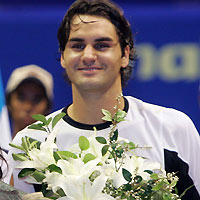 Roger Federer of Switzerland pose with flowers after the finals of the Thailand Open tennis tournament in Bangkok October 2, 2005. 