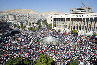 Thousands of Syrians rally in central Damascus in support of the government, on the eve of a UN Security Council meeting on a UN report that implicated Damascus in the murder of Lebanese ex-premier Rafiq Hariri. [AFP]