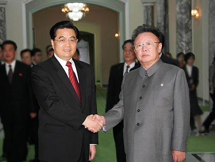 President Hu Jintao (left) shakes hands with the Democratic People's Republic of Korea leader Kim Jong-Il upon his arrival at Pyongyang Airport on Friday. Hu arrived in Pyongyang for a three-day official visit.(