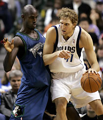 Mavericks forward Dirk Nowitzki (R) works for position against Minnesota Timberwolves forward Kevin Garnett during second half NBA action in Dallas, Texas, December 18, 2005. 