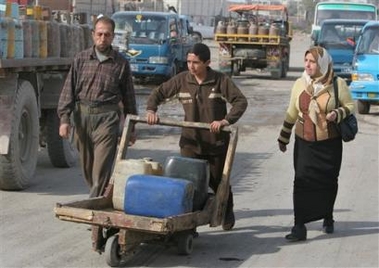 Iraqis arrive at a gas station to fill containers with kerosene in Baghdad, Iraq, Monday, Dec. 19, 2005. 